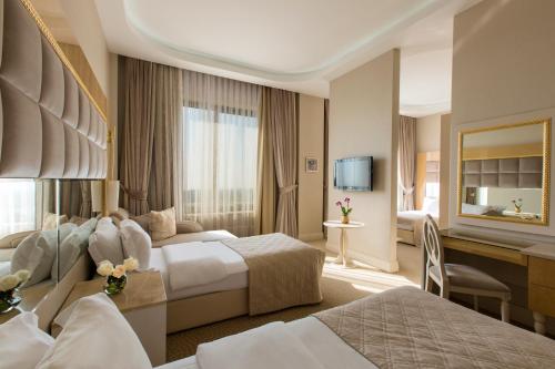 a hotel room with two beds and a desk at Gabala Garden Hotel in Gabala