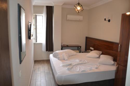 a bedroom with a bed with white towels on it at Marka Hotel in Antalya