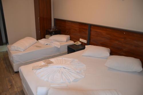 two beds in a hotel room with towels on them at Marka Hotel in Antalya