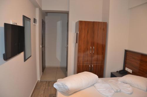 a bedroom with a bed and a dresser and a television at Marka Hotel in Antalya