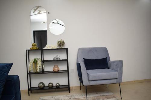 a living room with a chair and a mirror at Luxury Apartments in Lagos
