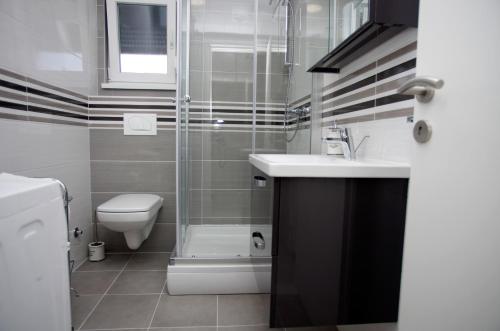 uma casa de banho com um WC, um lavatório e um chuveiro em Apartman Barbara em Trogir