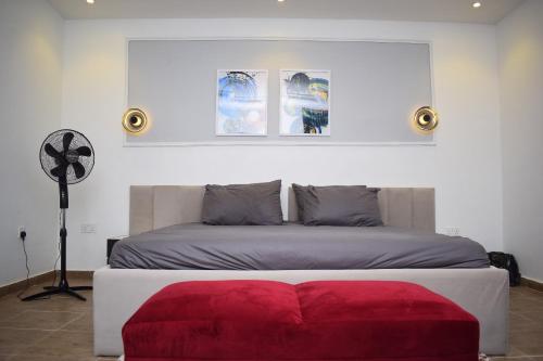 - une chambre avec un lit doté d'un pouf rouge dans l'établissement Luxury Apartments, à Lagos