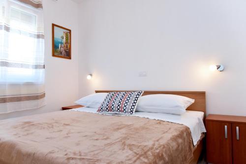 um quarto com uma cama e uma janela em Apartman Barbara em Trogir