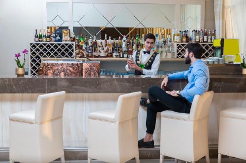 two men sitting in chairs in front of a bar at Gabala Garden Hotel in Gabala