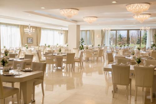 Gabala Garden Hotel في غابالا: غرفة طعام بها طاولات وكراسي وثريات