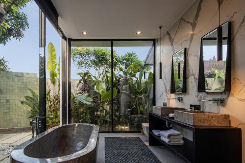 a bathroom with a large tub and large windows at VILLA GIMA 1 - 5 bedroom UMALAS in Kerobokan