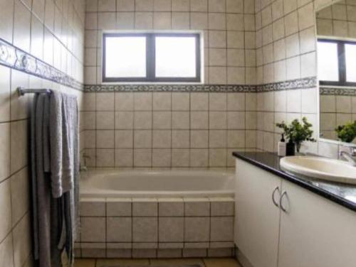 Kelso的住宿－Marula Mews T17 Villa - Selborne Golf Estate，带浴缸和盥洗盆的浴室