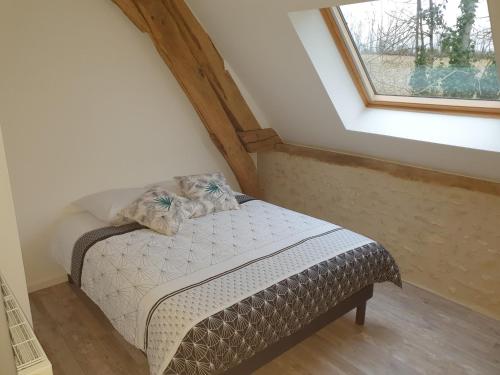 uma pequena cama num quarto com uma janela em L'élégant Gîtes de Moiscourt em Gisors