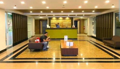 碧瑶Megatower Residence shortwalk1 SM Burnham Night Market的坐在大堂椅子上的男人