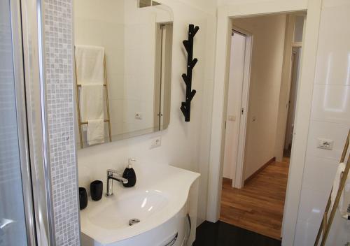 a white bathroom with a sink and a mirror at Il Casale del Borgo in Cancellara