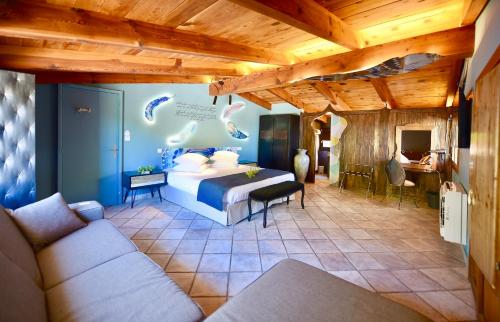 1 dormitorio con 1 cama y 1 sofá en una habitación en Hôtel Domaine A Flatta, en Calenzana