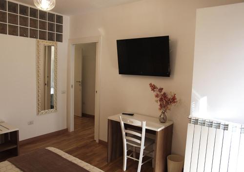a living room with a table and a television on the wall at Il Casale del Borgo in Cancellara
