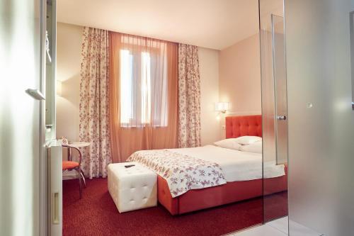 a hotel room with a bed and a window at Continental Forum Sibiu in Sibiu