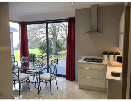a kitchen with a table and chairs and a window at Luxurious Studio Apartment in Fahan Co Donegal in Fahan