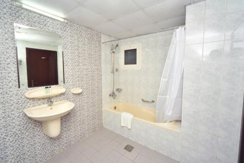 a bathroom with a sink and a toilet and a shower at Nejoum Al Emarat in Sharjah