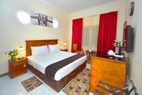 a hotel room with a bed and a television at Nejoum Al Emarat in Sharjah