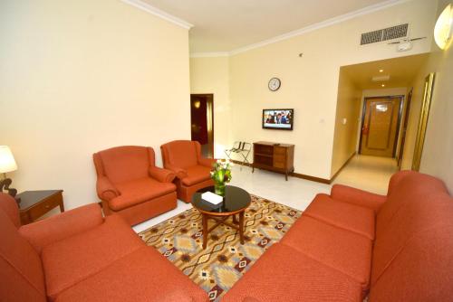 a living room with a couch and two chairs and a table at Nejoum Al Emarat in Sharjah