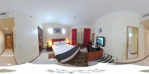 a hotel room with a bed and a mirror at Nejoum Al Emarat in Sharjah