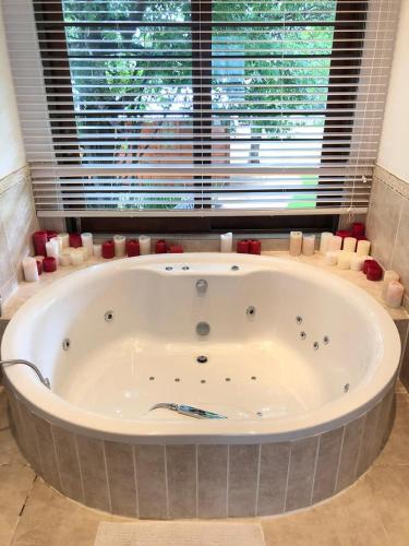 a large bath tub in a room with a window at FM GUEST LODGE Comfort, Tranquility & Peace of Mind in Johannesburg