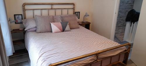 Cosy Mews House Close to Harbour في بورثمادوج: غرفة نوم مع سرير كبير مع العديد من الوسائد