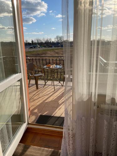 a balcony with a view of a table and a patio at Zajazd nad Sanem in Jarosław