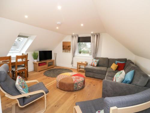 a living room with a couch and chairs and a tv at Taorbeag at Taormina in Fort William