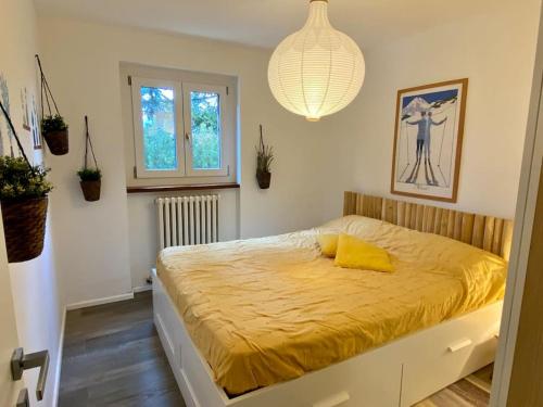 une chambre avec un lit avec une couverture jaune dessus dans l'établissement TRILOCALE SULLE PISTE Appena RISTRUTTURATO, à Sauze dʼOulx