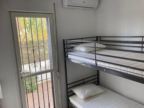 ビジャマルティンにあるHolidayhome Villamartin Lomas del Golfの二段ベッド2台と窓が備わる客室です。