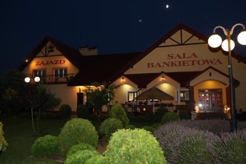 a building with a restaurant at night at Zajazd nad Sanem in Jarosław