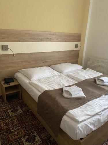 two beds in a hotel room with towels on them at City Centre in Prague