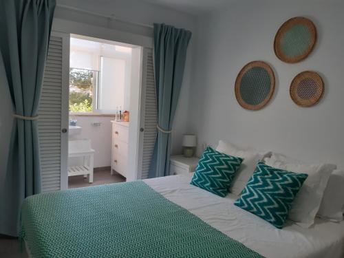 a bedroom with a bed with green sheets and a bathroom at Beautiful Apartment in Pollença Gotmar in El Port