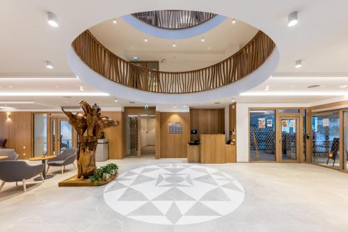 a lobby with a tree in the middle of it at RAJ zdravia in Bratislava