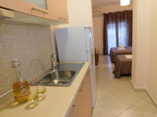 a kitchen with a sink and a refrigerator and wine glasses at Anna House 2 in Sarti