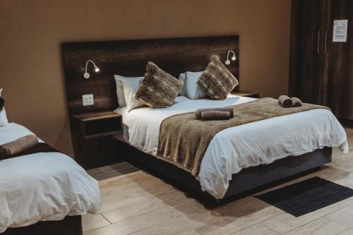 a bedroom with a large bed with two pillows at Casa Leitao Lodge in Phalaborwa