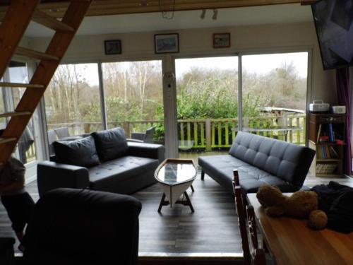 a living room with couches and a table at Le petit Marais n° 2 in Nouan-le-Fuzelier