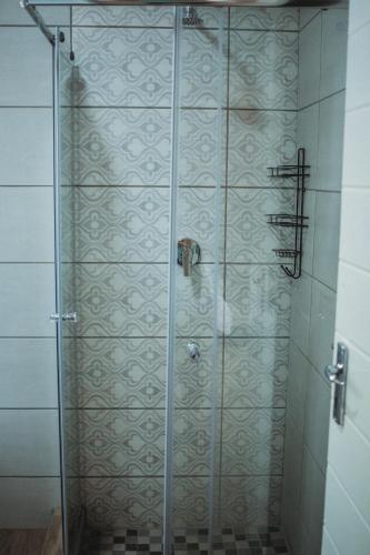 a shower with a glass door in a bathroom at Casa Leitao Lodge in Phalaborwa