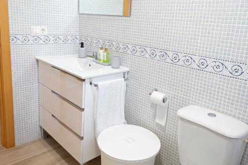 y baño con aseo blanco y lavamanos. en Arrecife 3 dormitorios, en Peñíscola