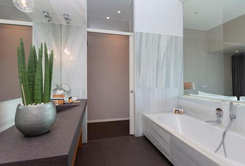 a bathroom with a tub, sink and mirror at Hotel Royal Passeig de Gracia in Barcelona