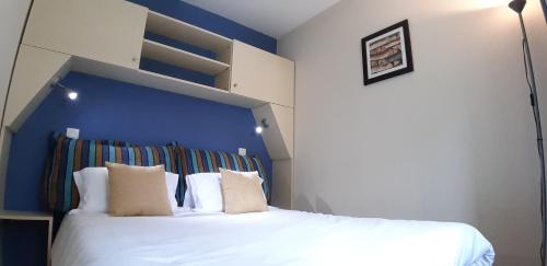 a bedroom with a large bed with a blue headboard at Appartement Lacanau entre Golf et Océan pour 4 personnes in Lacanau