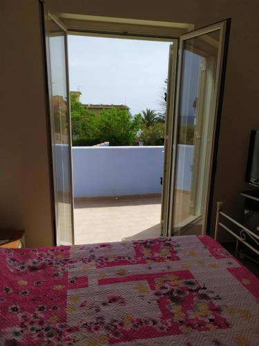 a bedroom with a bed and an open door to a balcony at Villa Azzurra Scale of the Turks in Realmonte