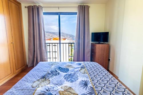 - une chambre avec un lit et une grande fenêtre dans l'établissement LULINA Two Bedroom by ALMA Holiday Rentals, à Funchal