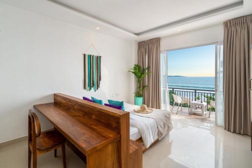 a bedroom with a desk and a view of the ocean at Outpost Weligama Beachfront in Weligama