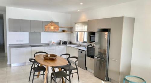 a kitchen with a table and chairs and a refrigerator at East Coast Beachfront Luxury - Eastern Blue Apartments in Poste Lafayette