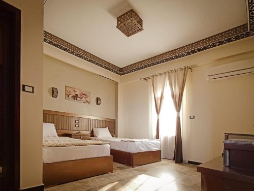 a bedroom with two beds and a window at Shabana House in Dahab