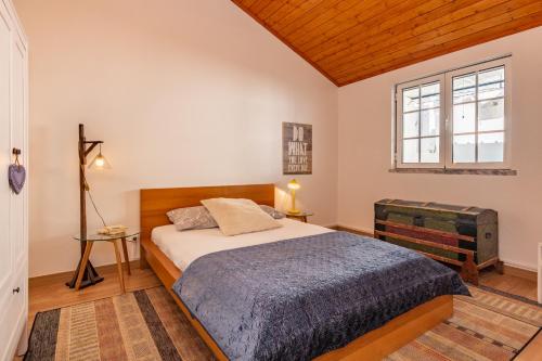 a bedroom with a bed and a window at ONZE in Grândola