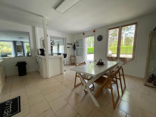 une cuisine et une salle à manger avec une table et des chaises dans l'établissement Agréable maison entre Zoo et Châteaux, à Contres