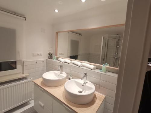 ein Badezimmer mit zwei Waschbecken und einem großen Spiegel in der Unterkunft Precioso apartamento, fantásticas vistas in Augustusburg