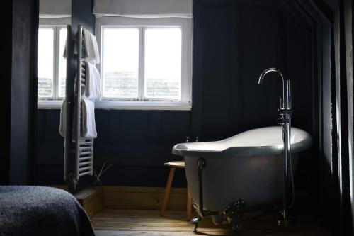 a bathroom with a bath tub and a window at Whitehouse Rye in Rye