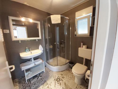 ein Bad mit einer Dusche, einem WC und einem Waschbecken in der Unterkunft Sobe Dragić in Zadar